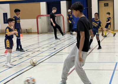 Kids playing indoor soccer in a gymnasium.