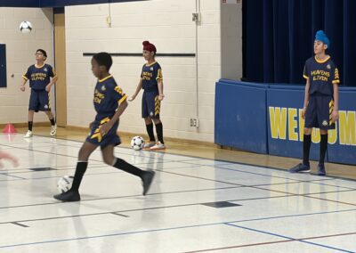 Two indoor soccer players in action on the court.