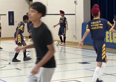 Young players engaged in a basketball game indoors.