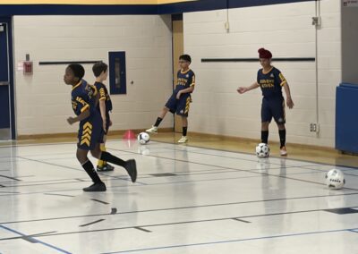 Youth indoor soccer players in action during a game.