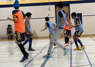 Young boys playing indoor basketball in a gymnasium.