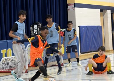 Youth basketball players in action during a game in a gym.