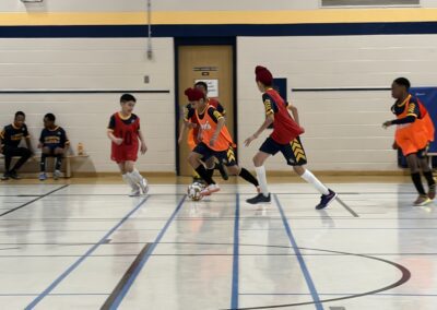 Young kids playing indoor basketball in a gym.