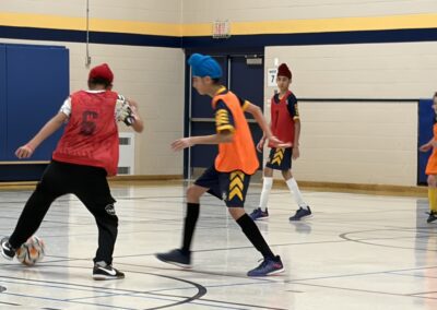 Youth playing indoor basketball in colorful jerseys and headbands.