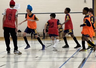 Youth basketball players in action on indoor court.