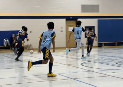 Kids playing basketball in a gymnasium.
