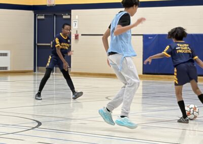 Youth basketball players in action during a game inside a gym.