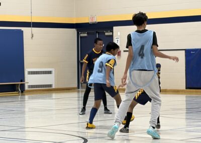 Kids playing basketball in a gymnasium during a game.