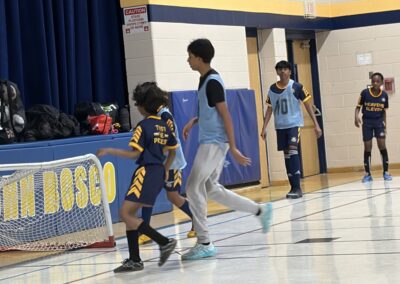 Children playing basketball on an indoor court.