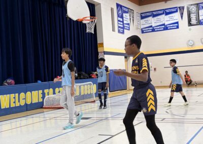 Kids playing basketball in a school gymnasium.