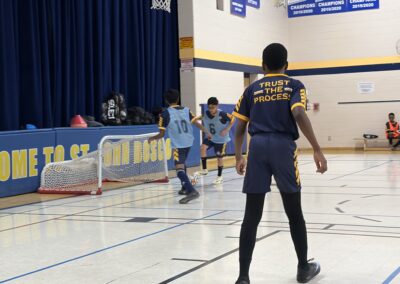 Kids playing basketball in a gym during a game.