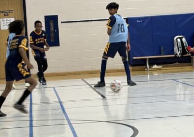 Indoor soccer game with players in action on the court.