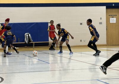 Youth basketball players in a gym actively competing for the ball.