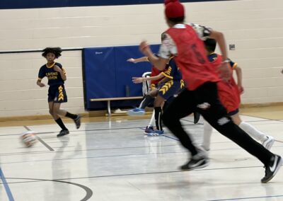 Youth basketball game in action with players running on the court.