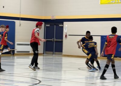 Two players competing in a basketball game inside a gymnasium.