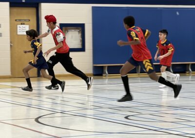 Youth basketball players sprinting on court during a game.