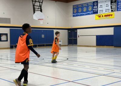 Children playing indoor basketball in a gymnasium.