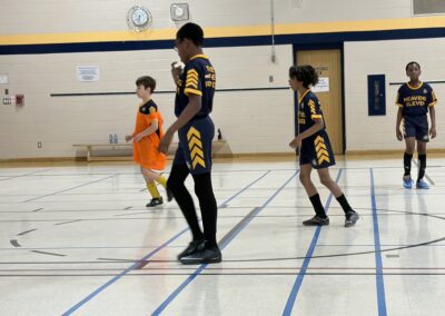 Kids playing basketball in a gymnasium.