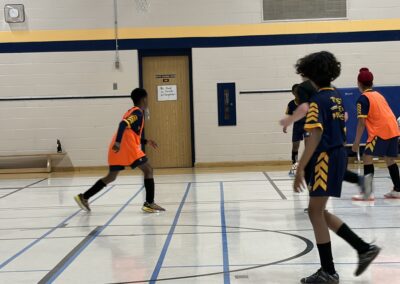 Youth basketball players in action during a game in a gym.