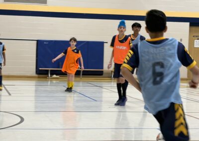 Kids playing indoor basketball in a gymnasium.